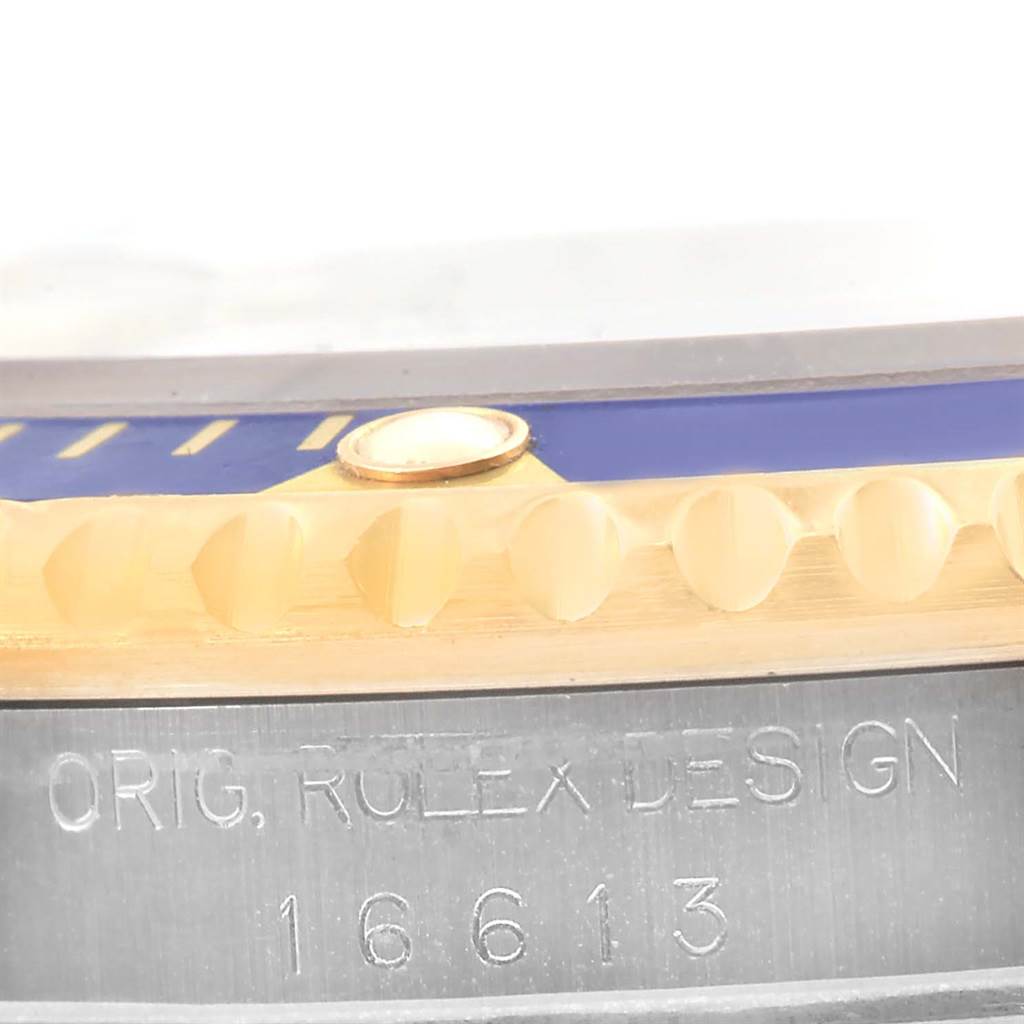 This image shows a close-up angle of the side of a Rolex Submariner 16613 Men
s Steel and Gold (two tone) Grey Dial 16613 Men
s Steel and Gold (two tone) Grey Dial watch, focusing on the bezel and model inscription.