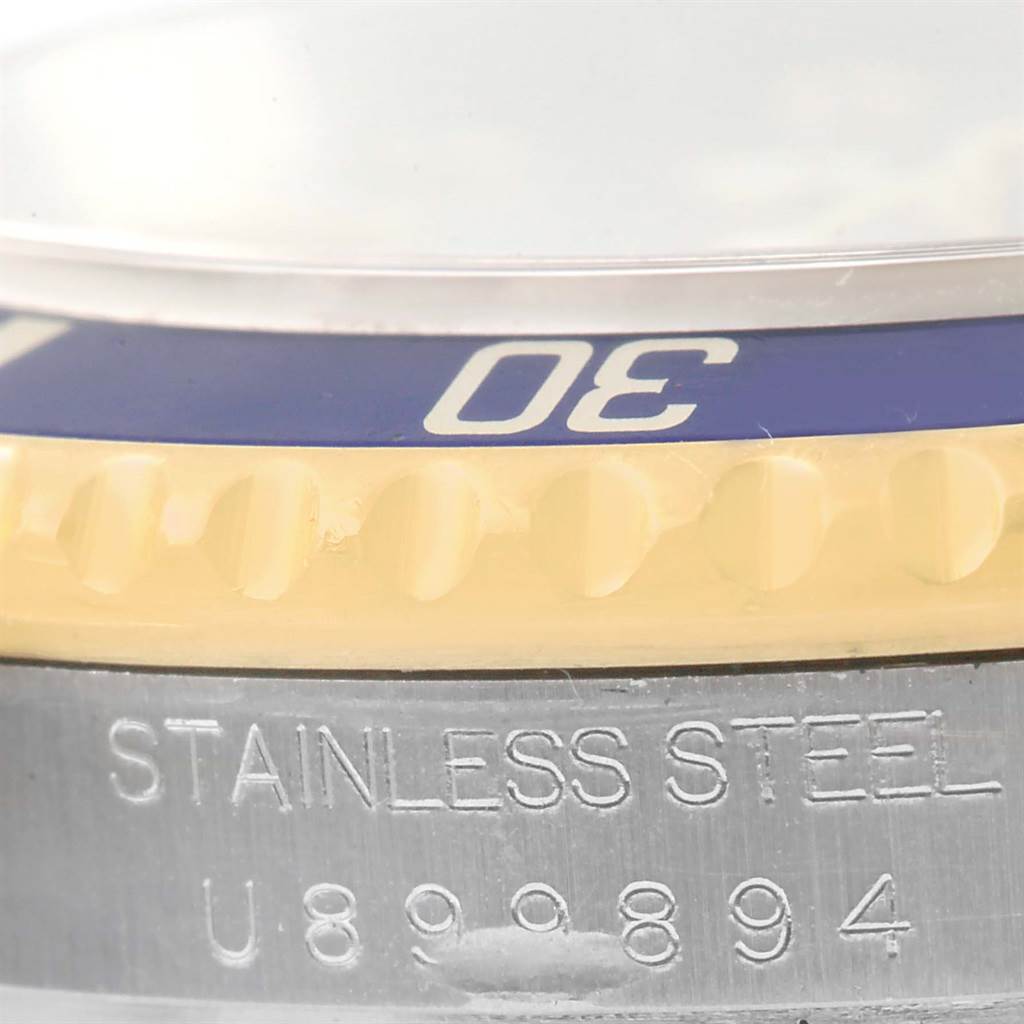 The image shows a close-up of the bezel and stainless steel case with the serial number of a Rolex Submariner 16613 Men
s Steel and Gold (two tone) Grey Dial 16613 Men
s Steel and Gold (two tone) Grey Dial watch.