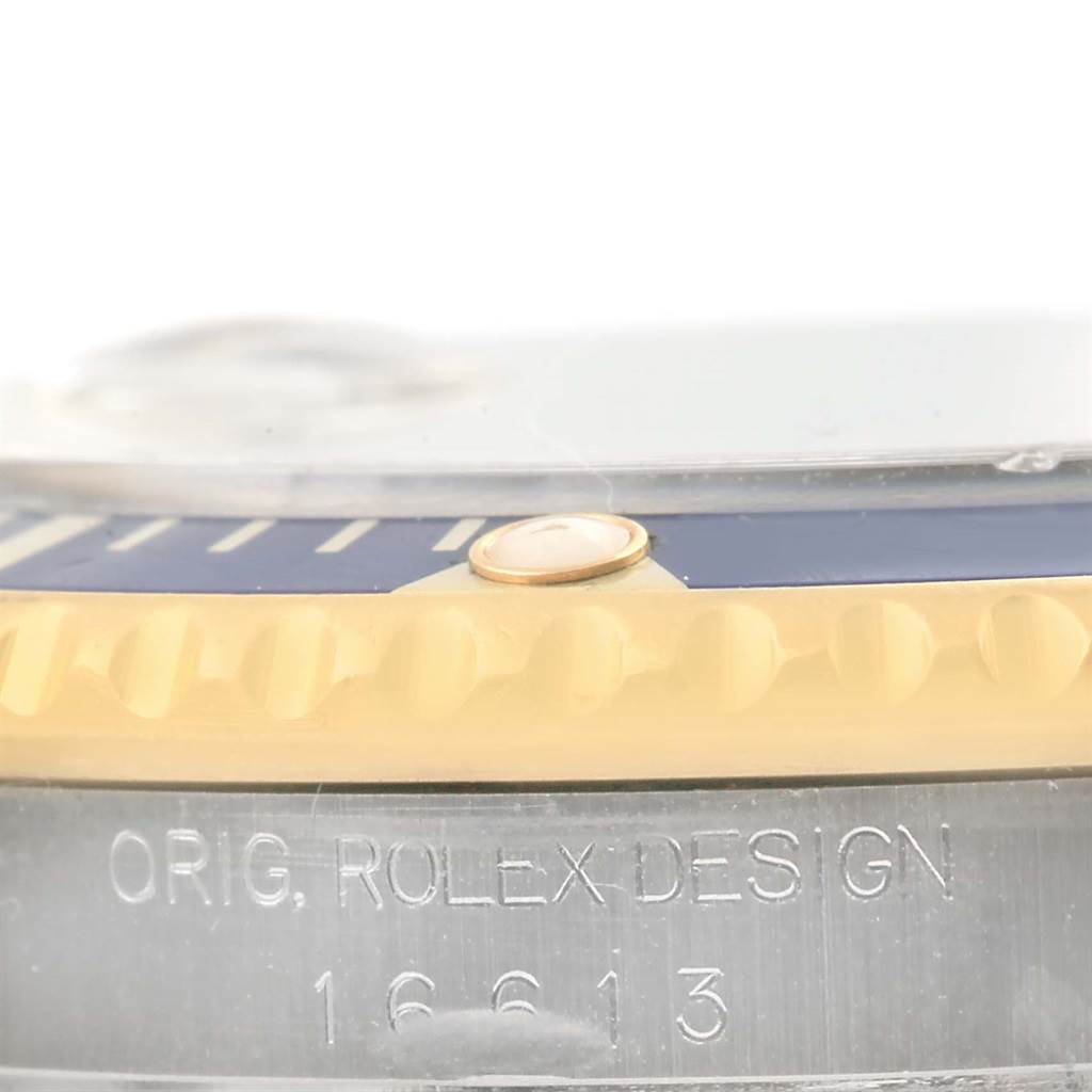 This close-up image shows the side view of a Rolex Submariner 16613 Men
s Steel and Gold (two tone) Grey Dial 16613 Men
s Steel and Gold (two tone) Grey Dial, highlighting the bezel and "ORIG. ROLEX DESIGN" engraving with the model number 16613.