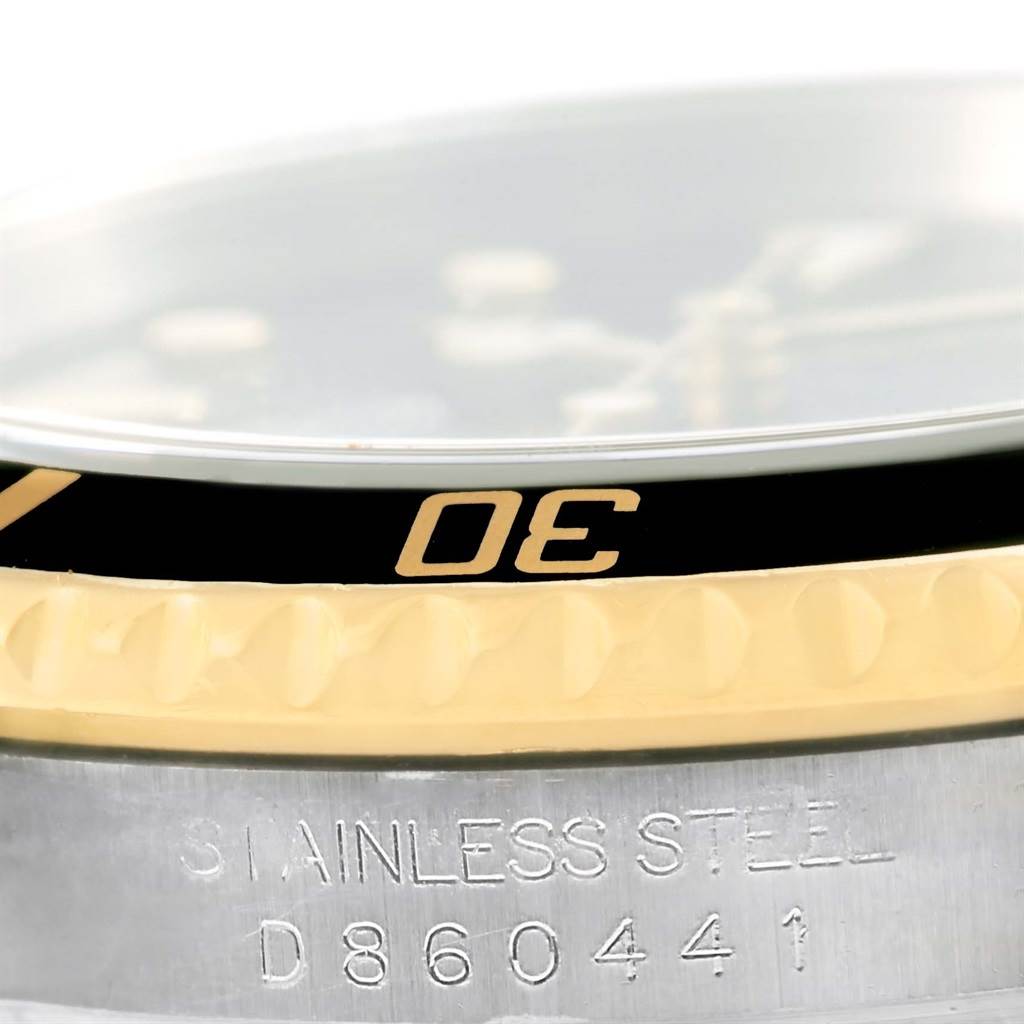This image shows a close-up of the bezel and case side of a Rolex Submariner 16613 Men
s Steel and Gold (two tone) Black Dial 16613 Men
s Steel and Gold (two tone) Black Dial, highlighting the “30” mark and “Stainless Steel” engraving.