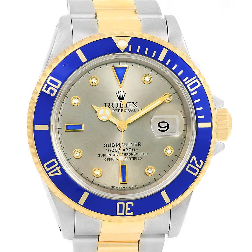 The image shows a front view of a Rolex Submariner 16613 Men
s Steel and Gold (two tone) Grey Dial 16613 Men
s Steel and Gold (two tone) Grey Dial watch with a blue bezel, silver dial, and two-tone bracelet.
