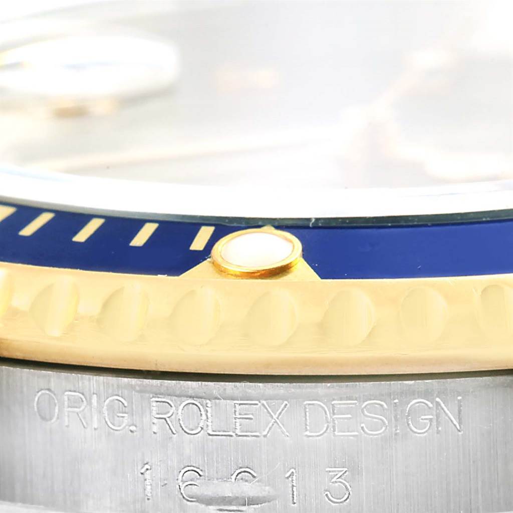 This close-up image of the Rolex Submariner 16613 Men
s Steel and Gold (two tone) Grey Dial 16613 Men
s Steel and Gold (two tone) Grey Dial shows the etched text and part of the bezel and case.