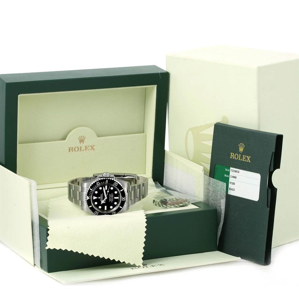 The Rolex Submariner 114060 Men
s Stainless Steel Black Dial 114060 Men
s Stainless Steel Black Dial watch is displayed front-on inside its box, with accompanying booklets and warranty card.