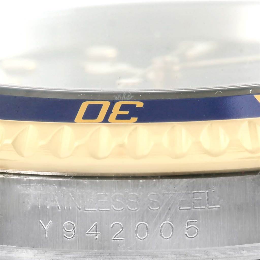 Close-up view of the Rolex Submariner 16613 Men
s Steel and Gold (two tone) Blue Dial 16613 Men
s Steel and Gold (two tone) Blue Dial watch bezel and part of the stainless steel case with the serial number.