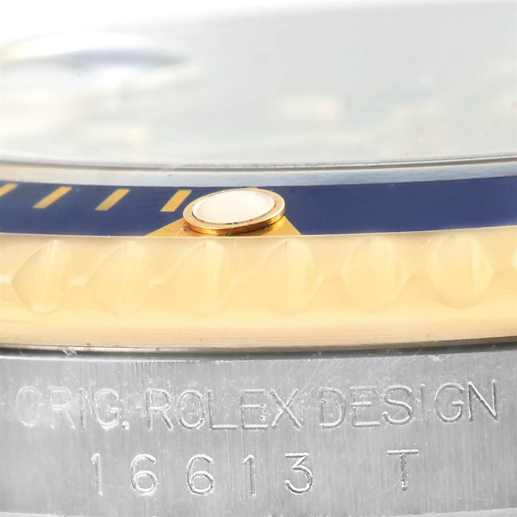 The image shows a close-up side view of the bezel and serial marking of a Rolex Submariner 16613 Men
s Steel and Gold (two tone) Blue Dial 16613 Men
s Steel and Gold (two tone) Blue Dial watch, model 16613.