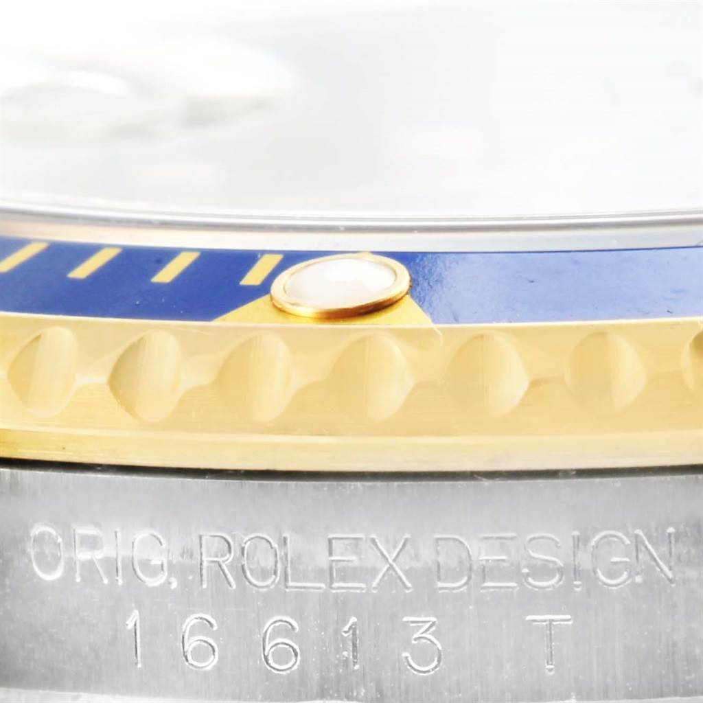 The image shows a close-up of the bezel and case edge of a Rolex Submariner 16613 Men
s Steel and Gold (two tone) Blue Dial 16613 Men
s Steel and Gold (two tone) Blue Dial watch, model 16613 T.
