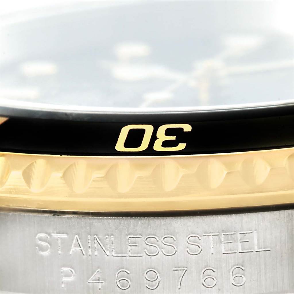 The image shows a close-up of the bezel and part of the case back of a Rolex Submariner 16613 Men
s Steel and Gold (two tone) Black Dial 16613 Men
s Steel and Gold (two tone) Black Dial watch, revealing the "30" mark and "STAINLESS STEEL" engraving.