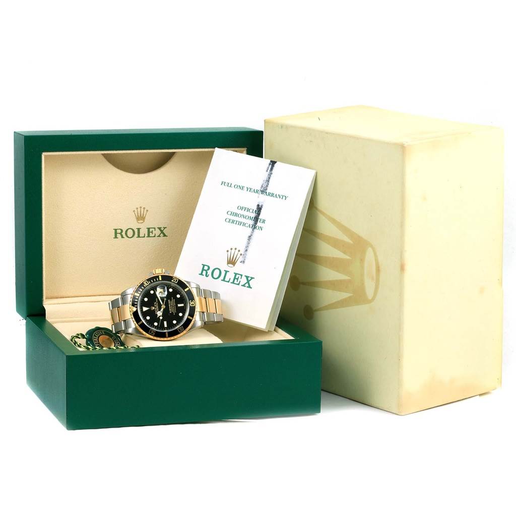 The Rolex Submariner 16613 Men
s Steel and Gold (two tone) Black Dial 16613 Men
s Steel and Gold (two tone) Black Dial watch is displayed in its box with warranty papers and accessories.