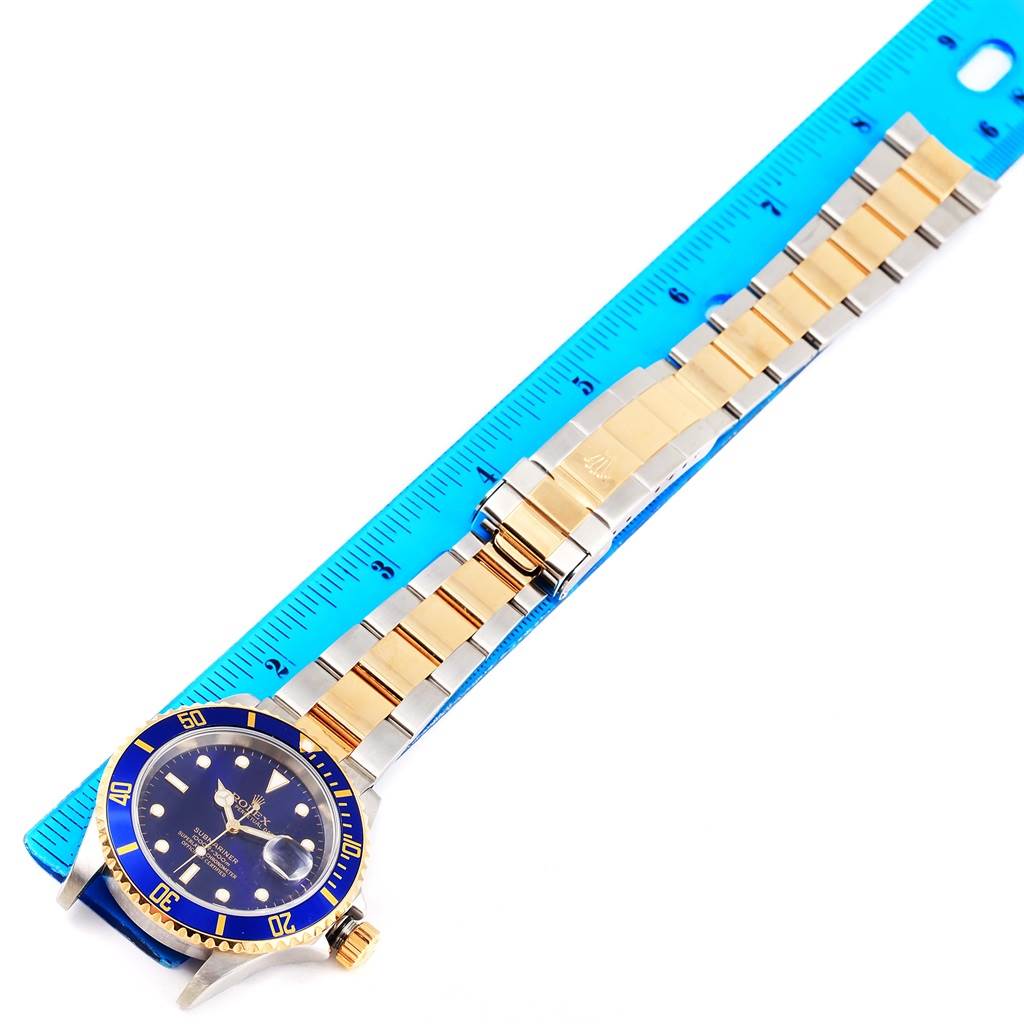 The Rolex Submariner 16613 Men
s Steel and Gold (two tone) Blue Dial 16613 Men
s Steel and Gold (two tone) Blue Dial watch is shown from a top-down angle, displaying the entire bracelet and face.