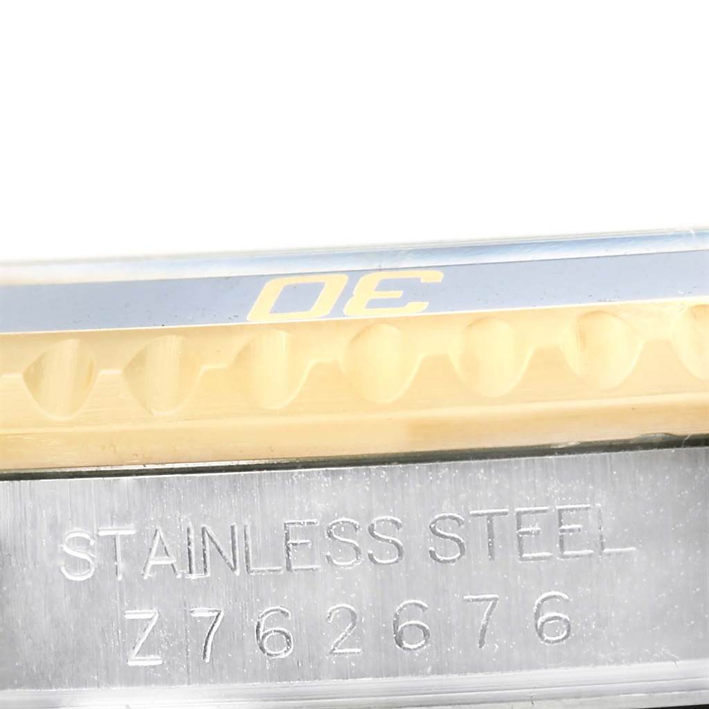 The image shows a close-up of the bezel and engraved case side of a Rolex Submariner 16613 Men
s Steel and Gold (two tone) Blue Dial 16613 Men
s Steel and Gold (two tone) Blue Dial watch.