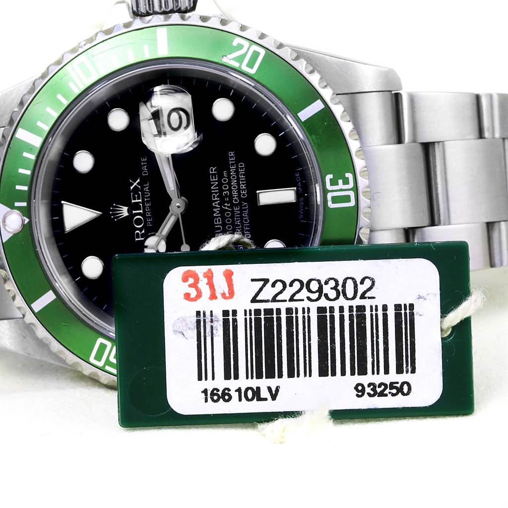 The image shows a partial front view of a Rolex Submariner 16610LV Men
s Stainless Steel Black Dial 16610LV Men
s Stainless Steel Black Dial watch with a green bezel and attached barcode tag.