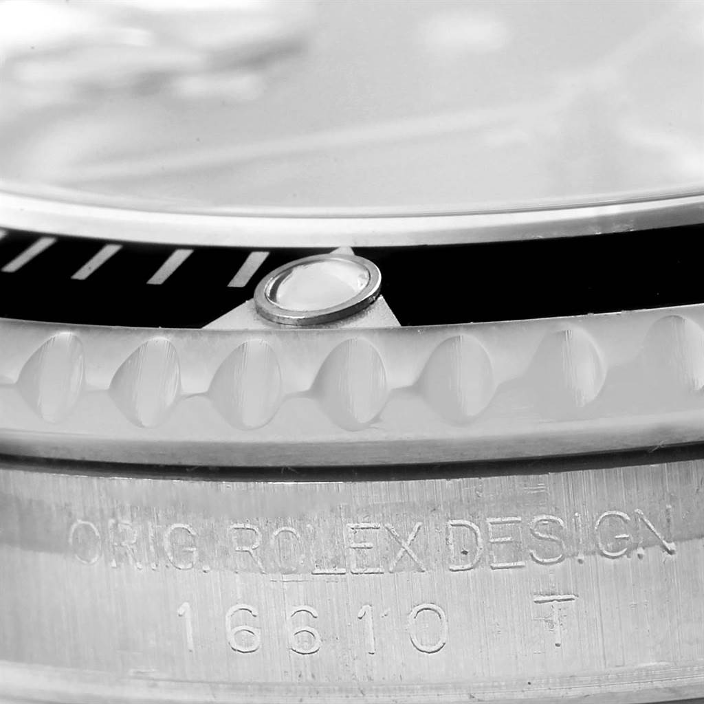 The image shows the side view of a Rolex Submariner 16610 Men
s Stainless Steel Black Dial 16610 Men
s Stainless Steel Black Dial watch focusing on the bezel, cyclops lens, and part of the case with model engraving.