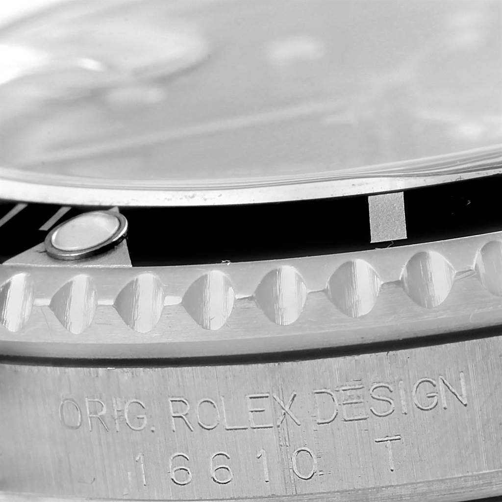 This image shows a close-up side view of the bezel and case edge of a Rolex Submariner 16610 Men's Stainless Steel Black Dial 16610 Men's Stainless Steel Black Dial watch, with "ORIG. ROLEX DESIGN 16610 T" engraved.