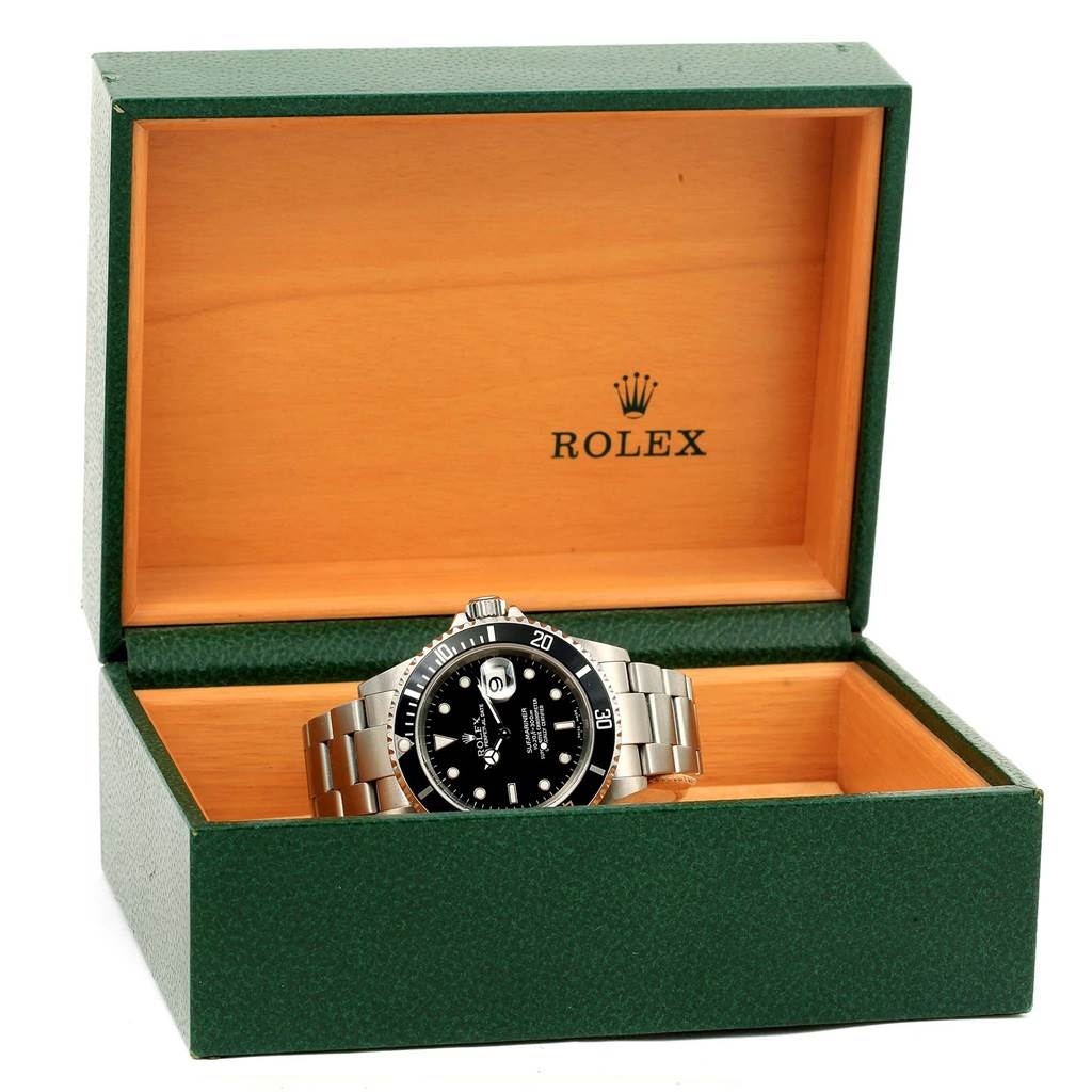 The image shows a Rolex Submariner 16610 Men's Stainless Steel Black Dial 16610 Men's Stainless Steel Black Dial watch displayed front-facing in an open green and wooden Rolex box.
