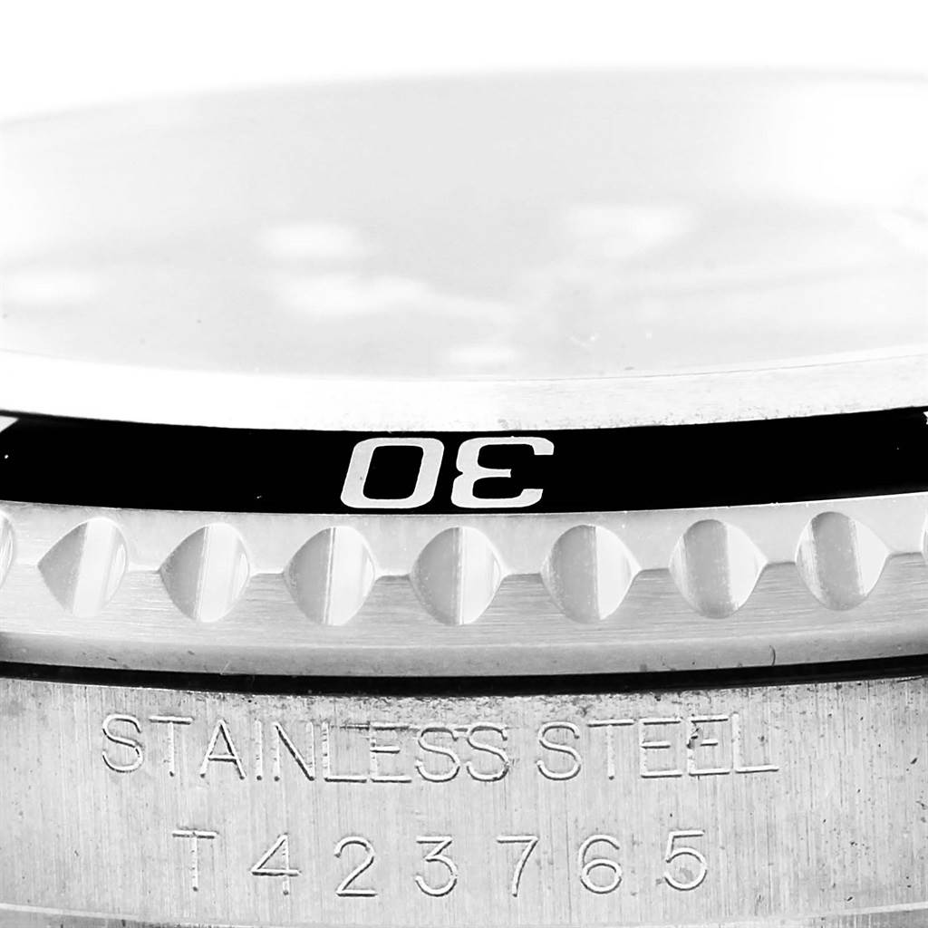 The image shows a close-up of the Rolex Submariner 16610 Men
s Stainless Steel Black Dial 16610 Men
s Stainless Steel Black Dial
s bezel and part of the case, highlighting the engraved details and the 30-minute marker.