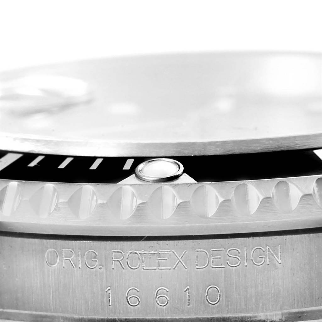 Close-up of a Rolex Submariner 16610 Men
s Stainless Steel Black Dial 16610 Men
s Stainless Steel Black Dial watch featuring the engraved model number "16610" and parts of the bezel and case.