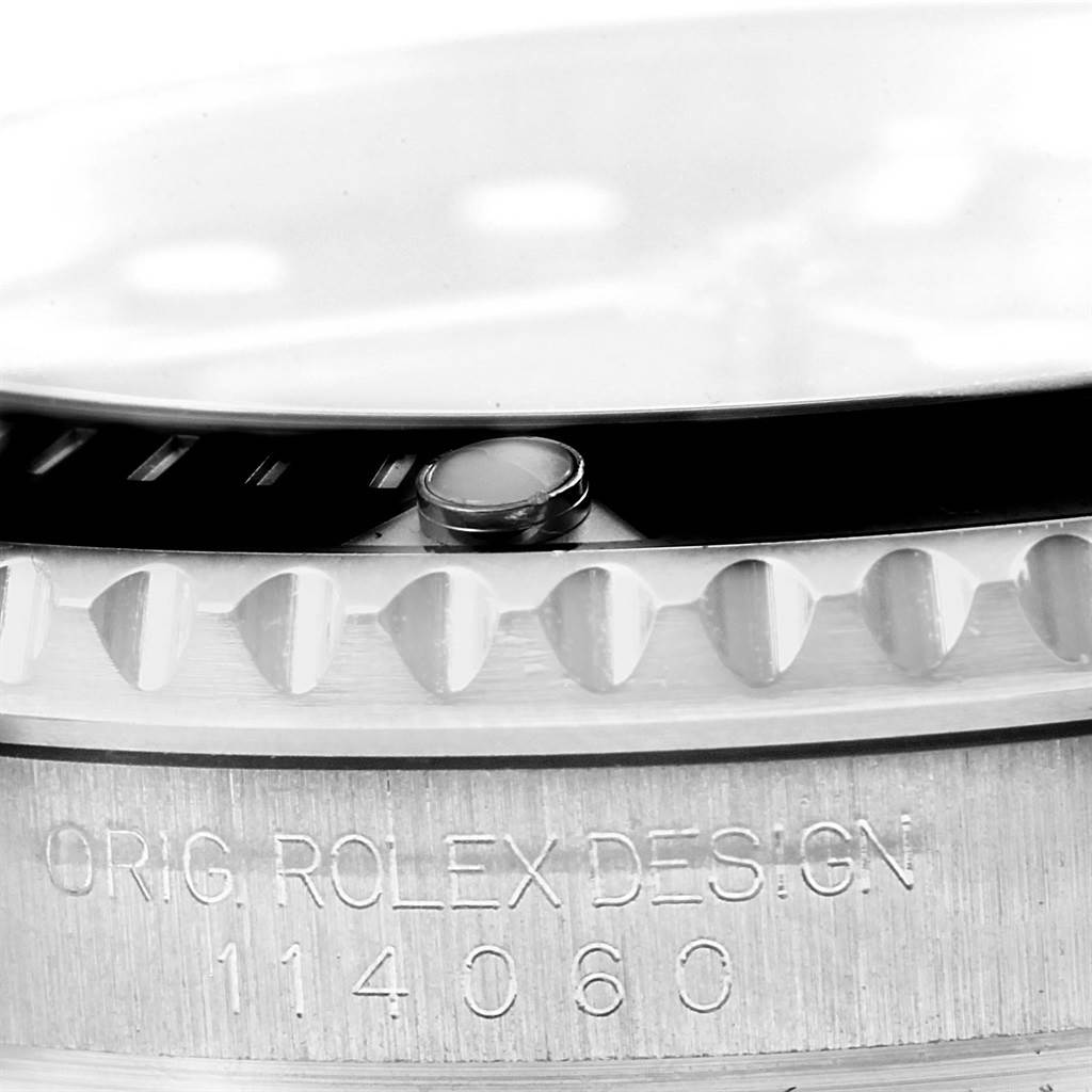 Close-up of the side view of a Rolex Submariner 114060 Men
s Stainless Steel Black Dial 114060 Men
s Stainless Steel Black Dial, showing the bezel, engraved model number, and design inscription.