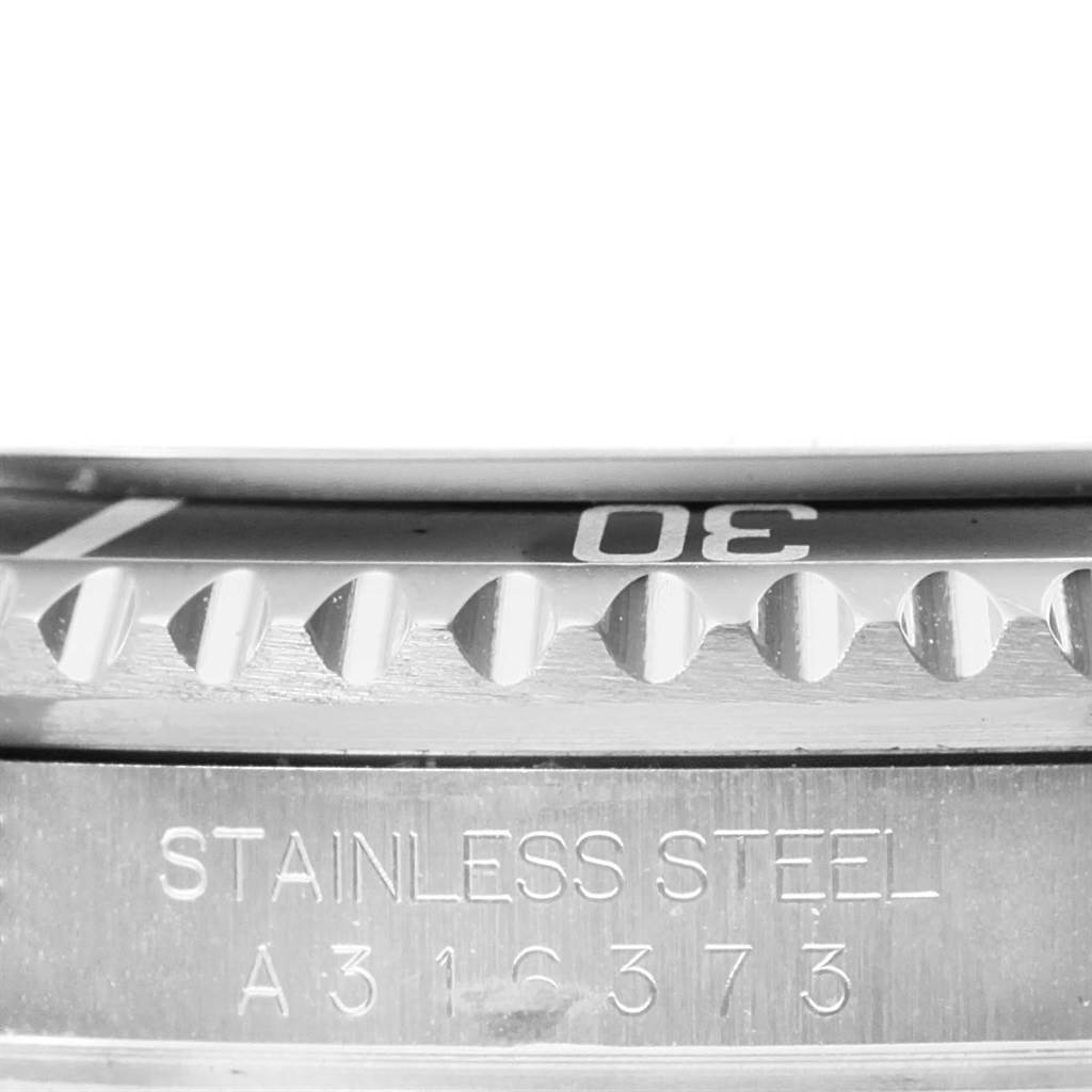 This close-up image shows the bezel and part of the stainless steel casing of a Rolex Submariner 16610 Men
s Stainless Steel Black Dial 16610 Men
s Stainless Steel Black Dial watch.