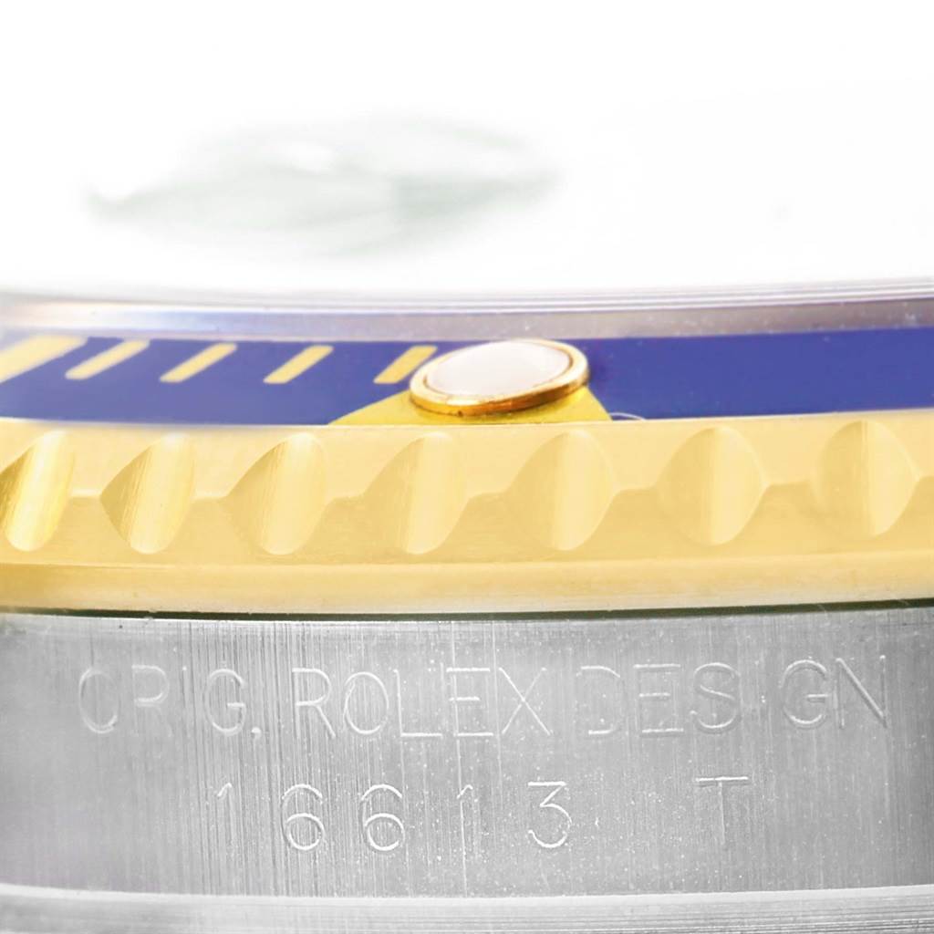 This image shows a close-up of the bezel and the engraved case side of a Rolex Submariner 16613 Men's Steel and Gold (two tone) Blue Dial 16613 Men's Steel and Gold (two tone) Blue Dial watch.