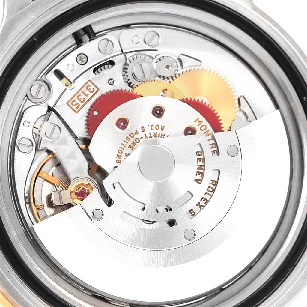 The image shows the intricate inner mechanism of a Rolex Submariner 16613 Men's Steel and Gold (two tone) Blue Dial 16613 Men's Steel and Gold (two tone) Blue Dial watch, featuring its gears and rotor.