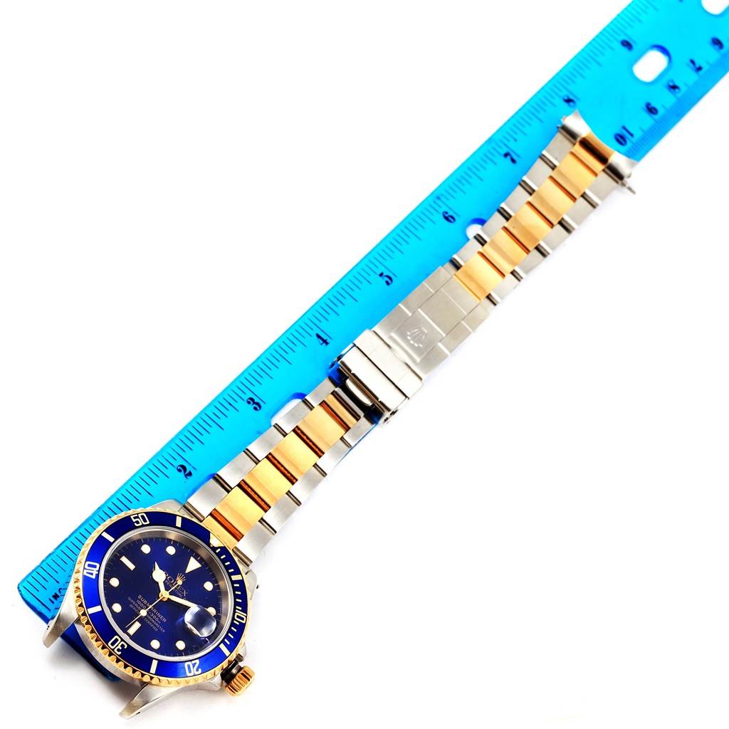 The Rolex Submariner 16613 Men's Steel and Gold (two tone) Blue Dial 16613 Men's Steel and Gold (two tone) Blue Dial watch is shown from a top view, displaying its face, bezel, and metal strap.