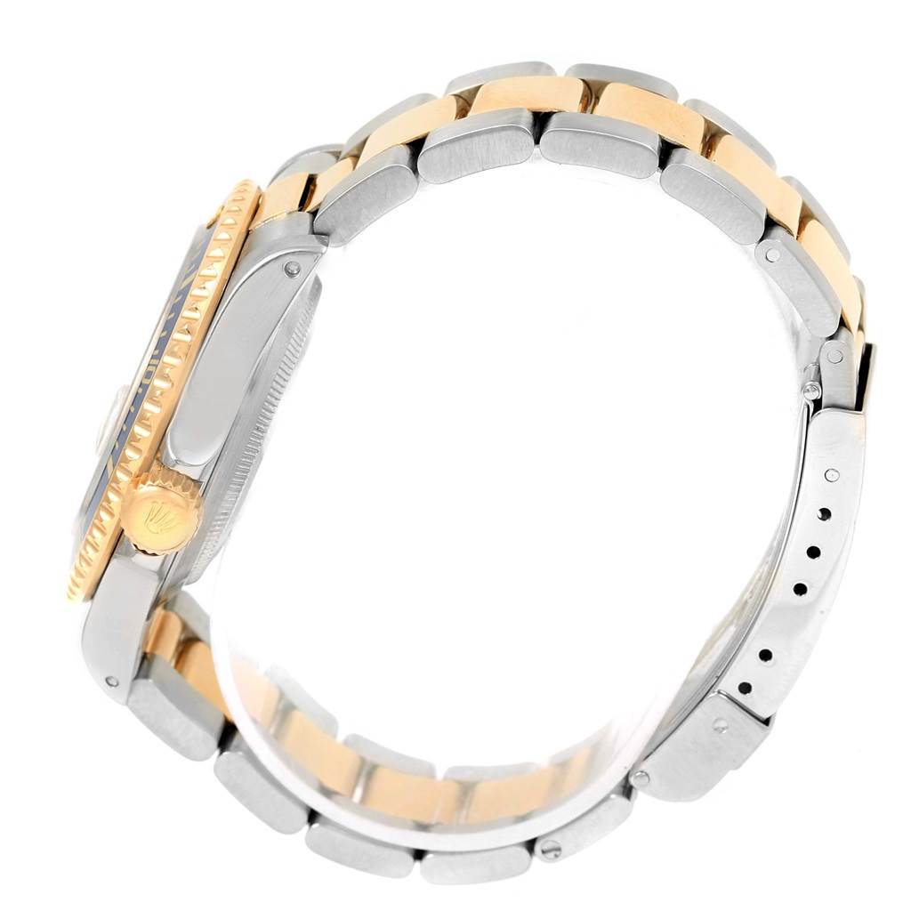 Side view of a Rolex Submariner 16613 Men's Steel and Gold (two tone) Blue Dial 16613 Men's Steel and Gold (two tone) Blue Dial watch showing the crown, bezel, and two-tone bracelet.