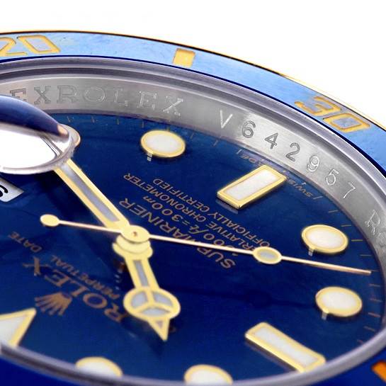 Close-up angle of the dial and bezel of a Rolex Submariner 116613 Men's Steel and Gold (two tone) Blue Dial 116613 Men's Steel and Gold (two tone) Blue Dial, highlighting the blue face, gold hour markers, and etched serial number.