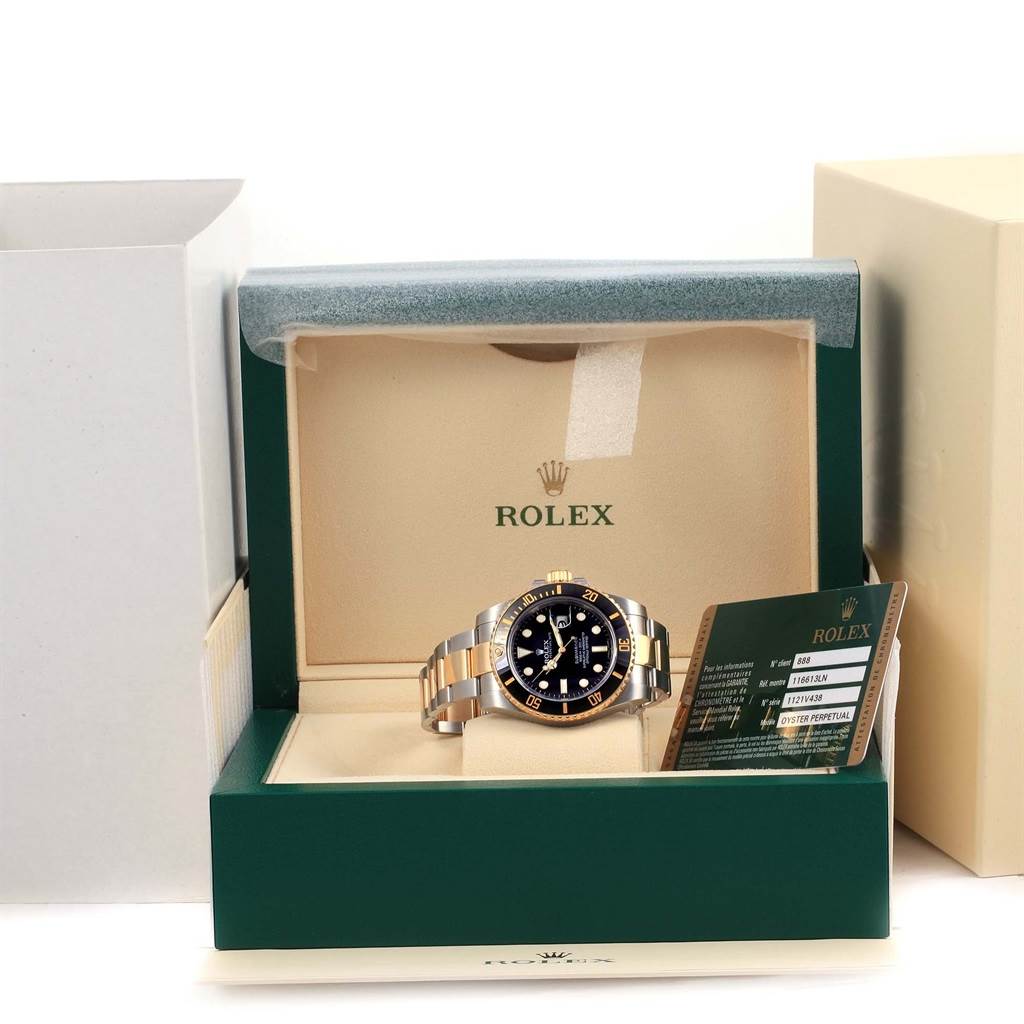 The image shows a front view of a Rolex Submariner 116613 Men
s Steel and Gold (two tone) Black Dial 116613 Men
s Steel and Gold (two tone) Black Dial watch, in its original box with associated documentation inside.