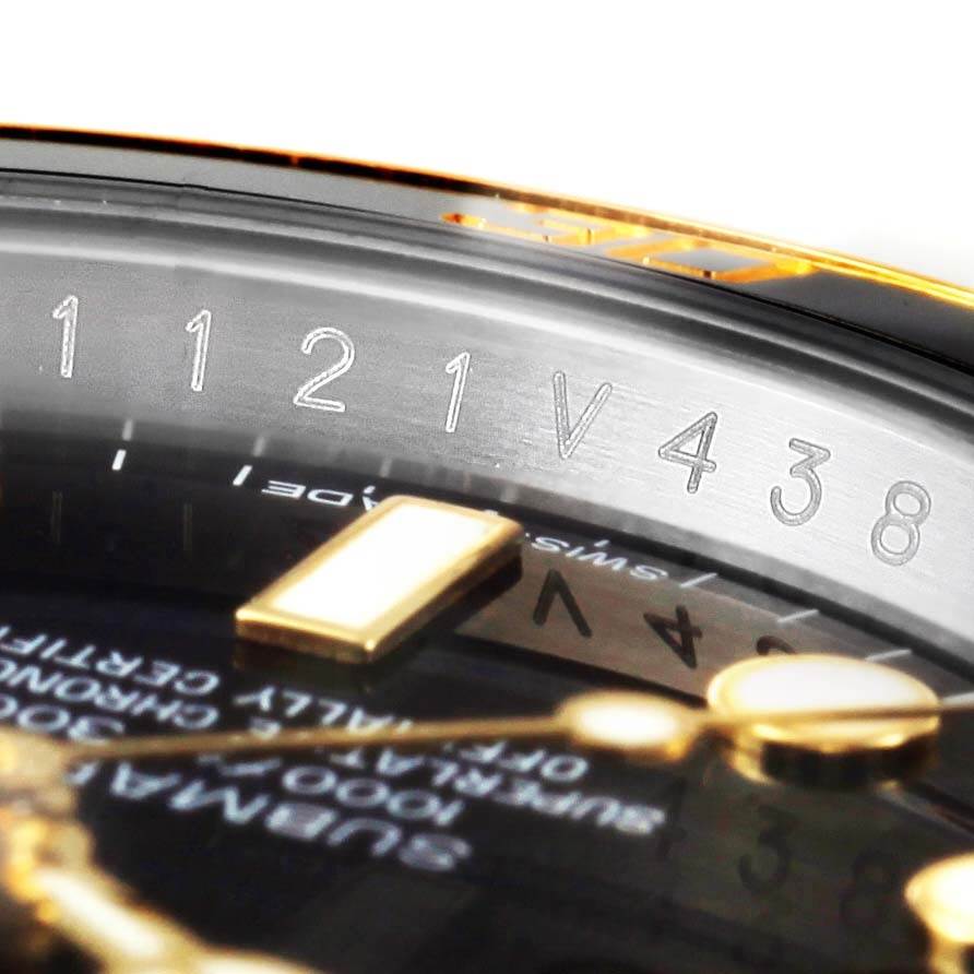 This close-up image shows a partial view of the dial and engraved serial numbers on the rehaut of a Rolex Submariner 116613 Men
s Steel and Gold (two tone) Black Dial 116613 Men
s Steel and Gold (two tone) Black Dial watch.
