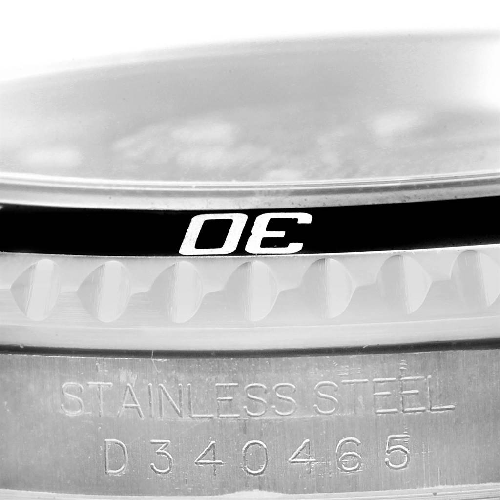 This image shows a close-up of the bezel and serial number of the Rolex Submariner 16610 Men
s Stainless Steel Black Dial 16610 Men
s Stainless Steel Black Dial watch, highlighting the "30" marker and stainless steel construction.
