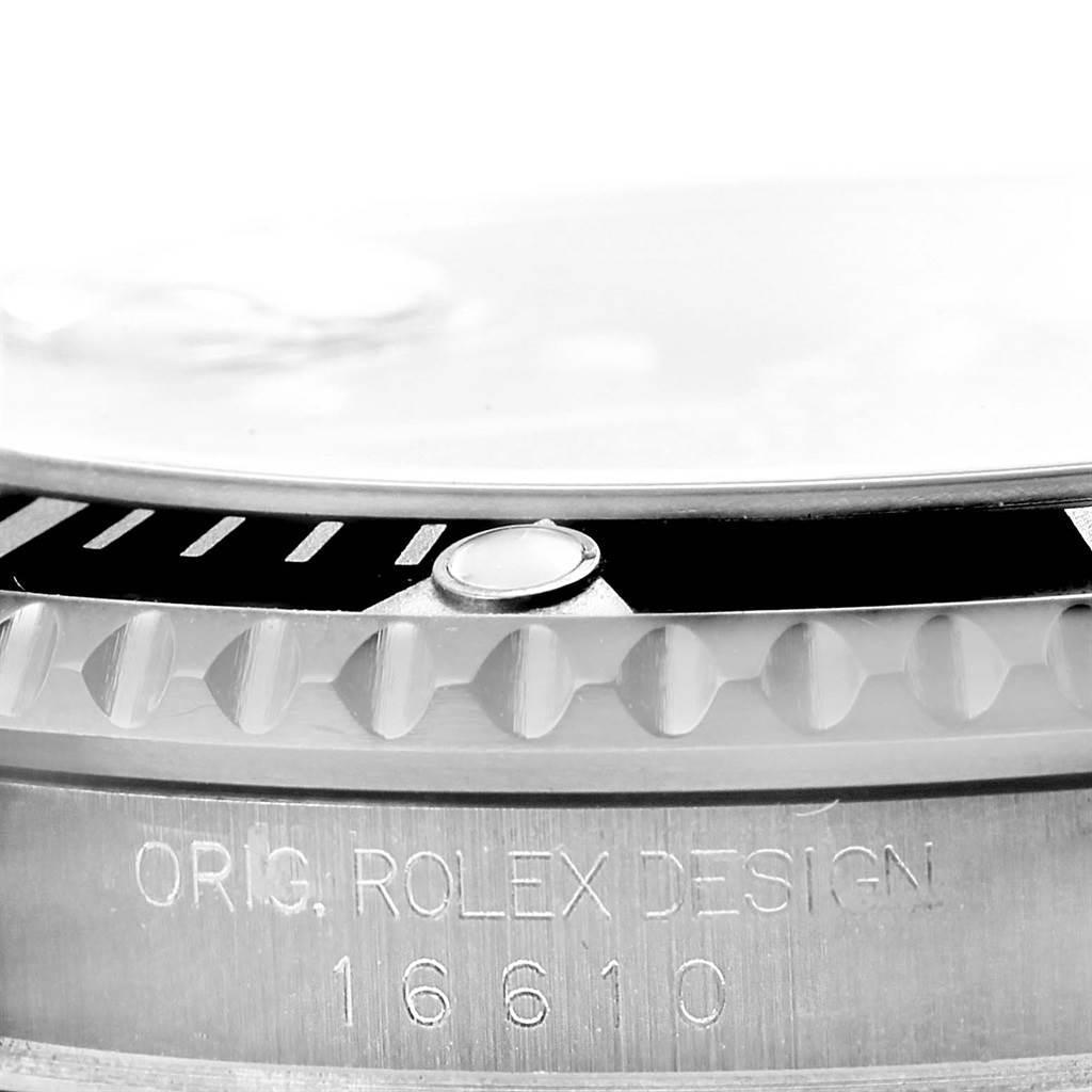 This image shows a close-up of the bezel, case, and engraving on the side of a Rolex Submariner 16610 Men's Stainless Steel Black Dial 16610 Men's Stainless Steel Black Dial watch, model 16610.