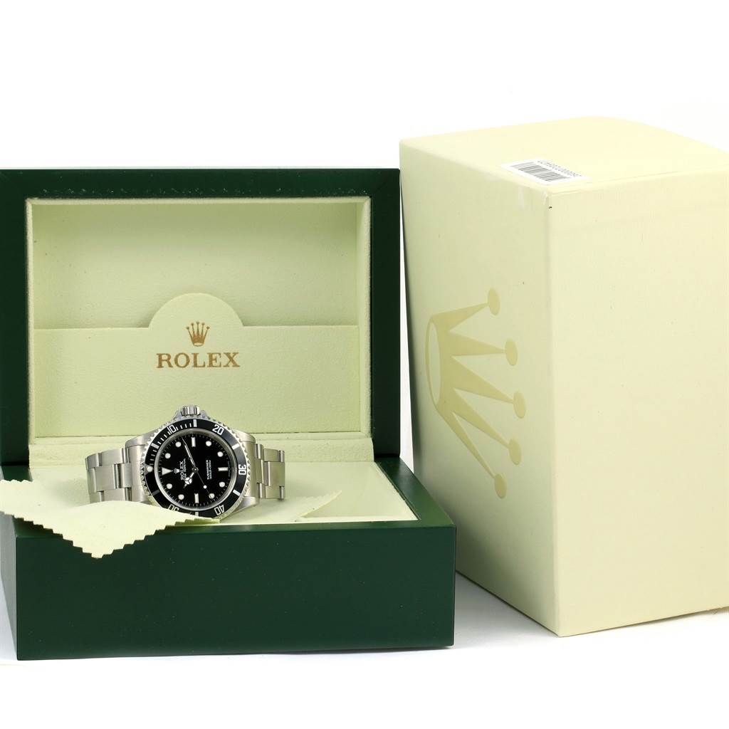 The Rolex Submariner 14060 Men's Stainless Steel Black Dial 14060 Men's Stainless Steel Black Dial watch is shown in an open green Rolex box with a beige outer box beside it.
