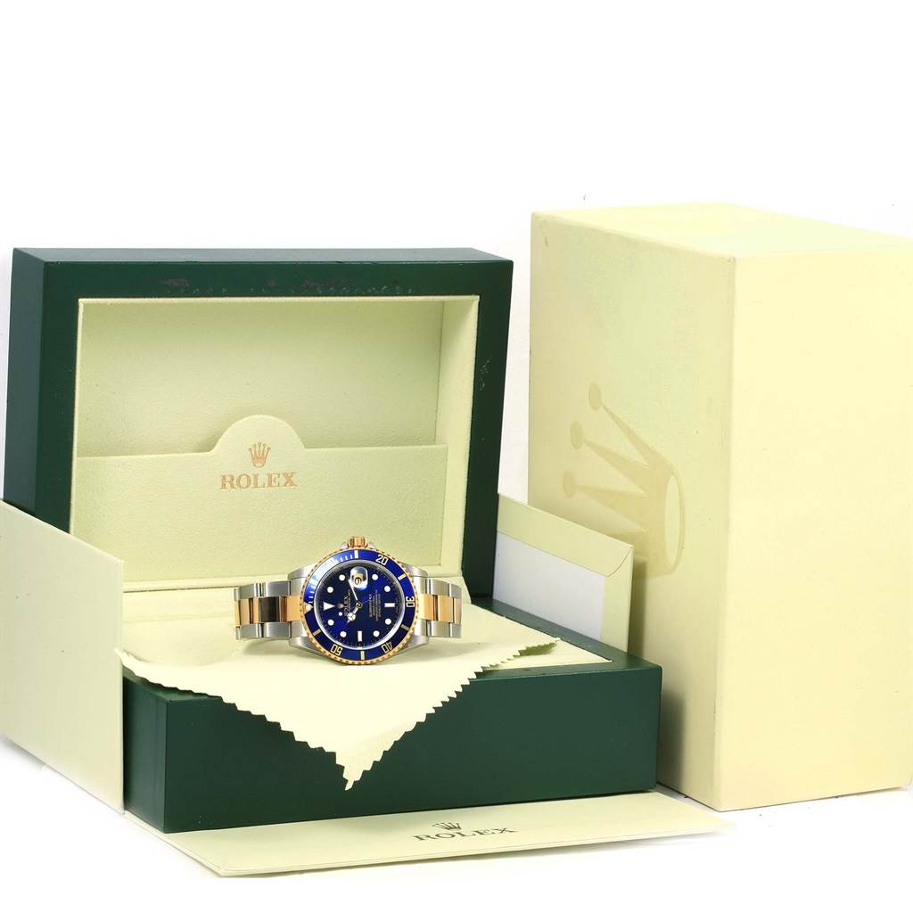 The Rolex Submariner 16613 Men
s Steel and Gold (two tone) Blue Dial 16613 Men
s Steel and Gold (two tone) Blue Dial watch is shown from the front in its open box, revealing the dial, bezel, and bracelet.