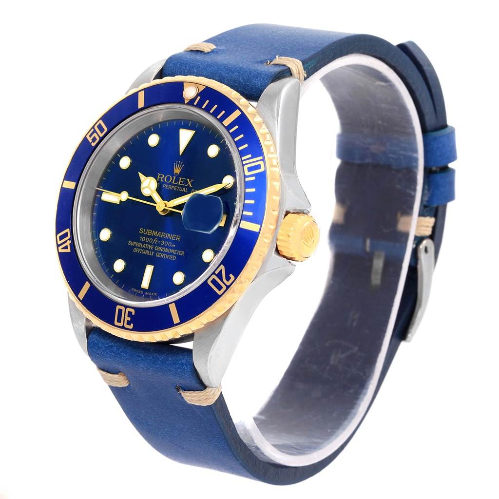The image shows a Rolex Submariner 16613 Men
s Steel and Gold (two tone) Blue Dial 16613 Men
s Steel and Gold (two tone) Blue Dial watch at an angle displaying its blue dial, rotating bezel, and blue leather straps.