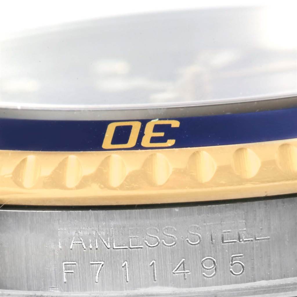 The image shows a close-up view of the bezel and part of the stainless steel case of a Rolex Submariner 16613 Men
s Steel and Gold (two tone) Blue Dial 16613 Men
s Steel and Gold (two tone) Blue Dial watch.