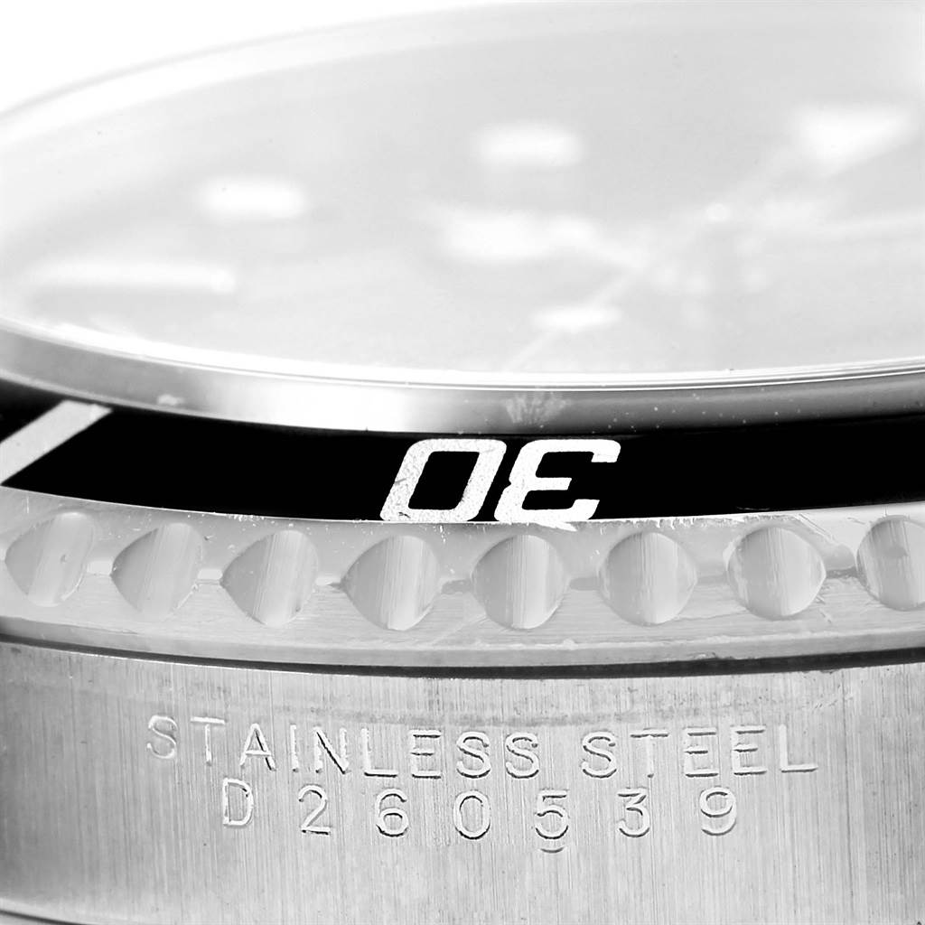 This close-up image of a Rolex Submariner 14060 Men
s Stainless Steel Black Dial 14060 Men
s Stainless Steel Black Dial watch shows the bezel, part of the dial, and the stainless steel case with the serial number.