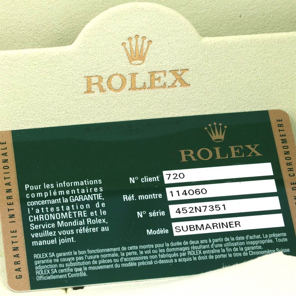 The image shows a green Rolex warranty card for the Submariner model with reference number 114060 and serial number 452N7351.