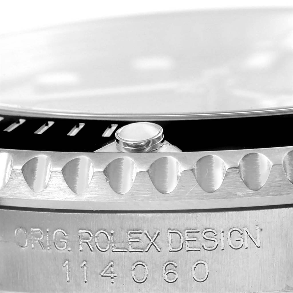 Close-up of a Rolex Submariner 114060 Men's Stainless Steel Black Dial 114060 Men's Stainless Steel Black Dial watch bezel and engraved model number 114060 on the case.