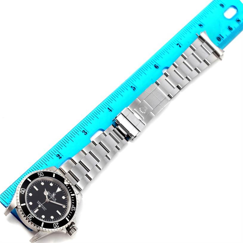 The image shows a Rolex Submariner 14060 Men's Stainless Steel Black Dial 14060 Men's Stainless Steel Black Dial watch and its bracelet laid flat next to a ruler for scale.