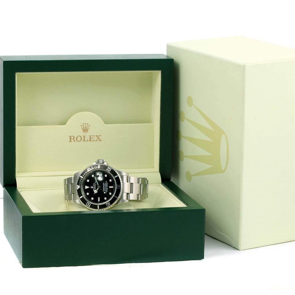 This image shows a Rolex Submariner 16610 Men's Stainless Steel Black Dial 16610 Men's Stainless Steel Black Dial watch in its open green and cream-colored box, with the outer box visible beside it.