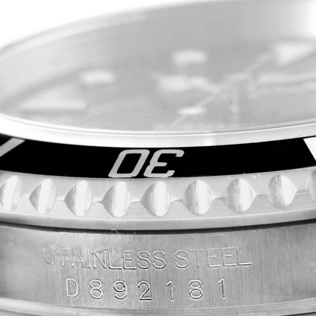 This close-up image shows the bezel and part of the case of a Rolex Submariner 16610 Men's Stainless Steel Black Dial 16610 Men's Stainless Steel Black Dial watch, highlighting the "30" minute marker and serial number engraving.