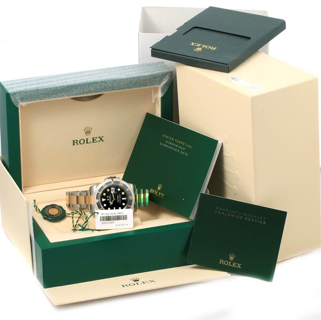 This image shows the Rolex Submariner 116613 Men
s Steel and Gold (two tone) Black Dial 116613 Men
s Steel and Gold (two tone) Black Dial watch with its open box, warranty booklets, tags, and additional packaging.