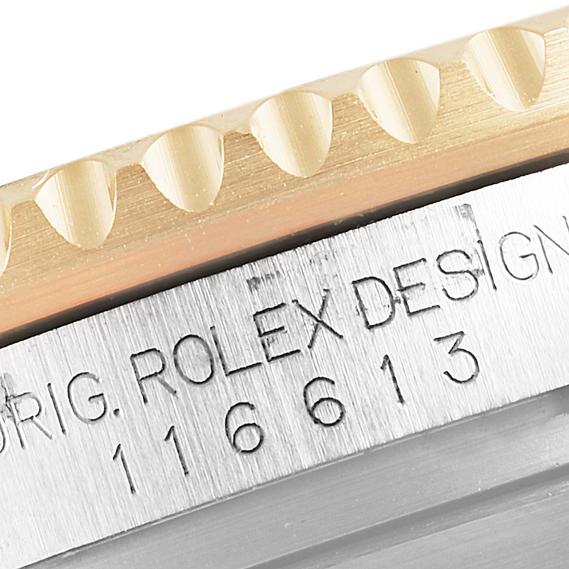 This close-up image shows the bezel and watch case side of a Rolex Submariner 116613 Men's Steel and Gold (two tone) Blue Dial 116613 Men's Steel and Gold (two tone) Blue Dial model with its engraved serial number.
