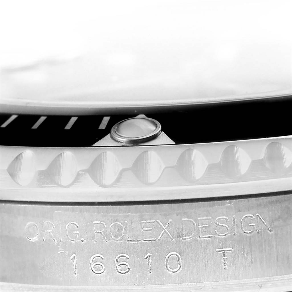 The image shows a close-up of the bezel and serial number engraving on a Rolex Submariner 16610 Men's Stainless Steel Black Dial 16610 Men's Stainless Steel Black Dial model 16610 watch.