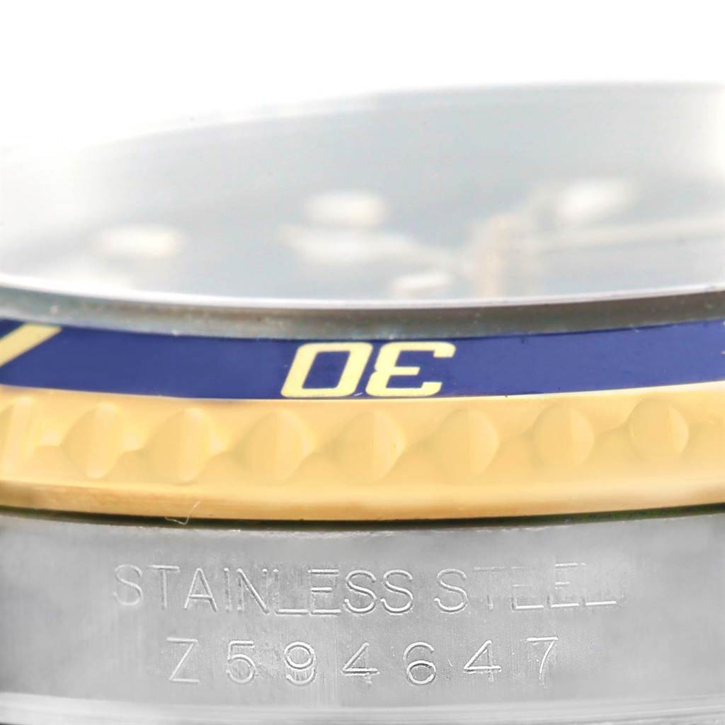 The image shows a close-up of the bezel and part of the case with the serial number of the Rolex Submariner 16613 Men's Steel and Gold (two tone) Blue Dial 16613 Men's Steel and Gold (two tone) Blue Dial.