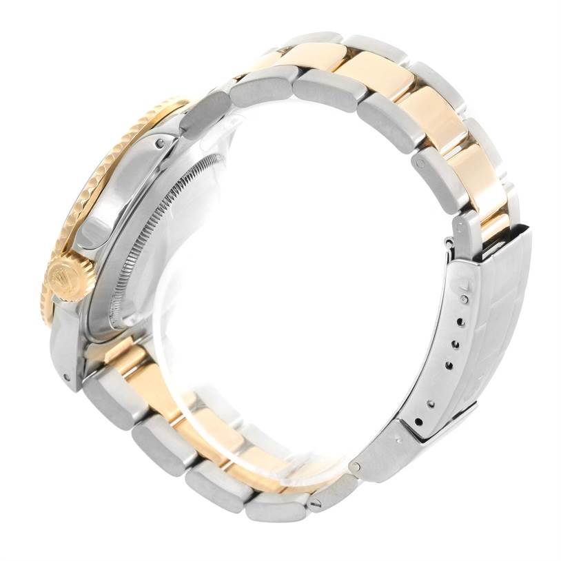 The image shows a side view of a Rolex Submariner 16613 Men
s Steel and Gold (two tone) Black Dial 16613 Men
s Steel and Gold (two tone) Black Dial watch, highlighting the gold and silver link bracelet and crown.