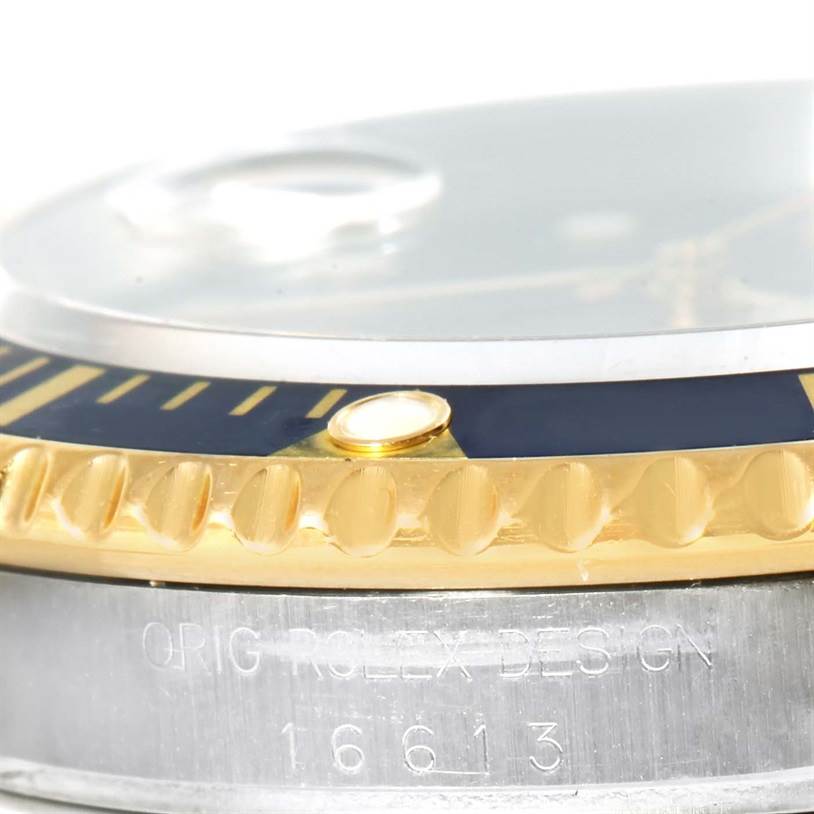 This close-up angle shows the bezel, crystal, and engraved case of the Rolex Submariner 16613 Men
s Steel and Gold (two tone) Black Dial 16613 Men
s Steel and Gold (two tone) Black Dial model.