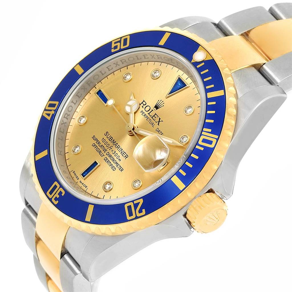 The image shows a Rolex Submariner 16613 Men's Steel and Gold (two tone) Champagne Dial 16613 Men's Steel and Gold (two tone) Champagne Dial watch at an angled view, highlighting the gold and blue bezel, crown, and part of the bracelet.