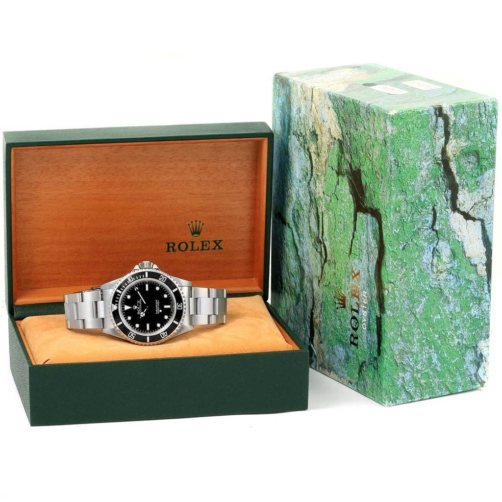 The Rolex Submariner 14060 Men's Stainless Steel Black Dial 14060 Men's Stainless Steel Black Dial watch is displayed front-facing in its green and wooden box, with the outer box visible to the right.