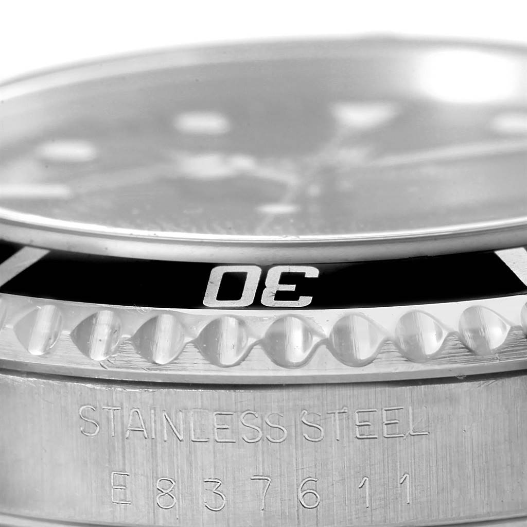 The image shows a close-up of the bezel, case, and part of the serial number of the Rolex Submariner 14060 Men's Stainless Steel Black Dial 14060 Men's Stainless Steel Black Dial watch.